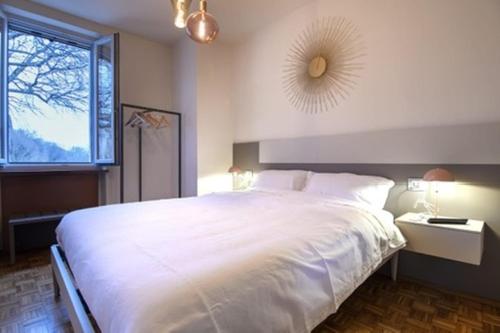 a bedroom with a large white bed and a window at Il Ninfeo in Volta Mantovana