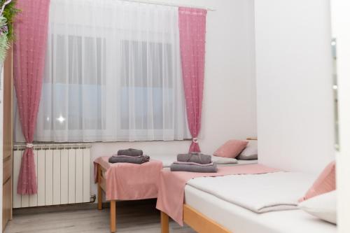 a room with two beds and a window at Apartman Orhideja in Gospić