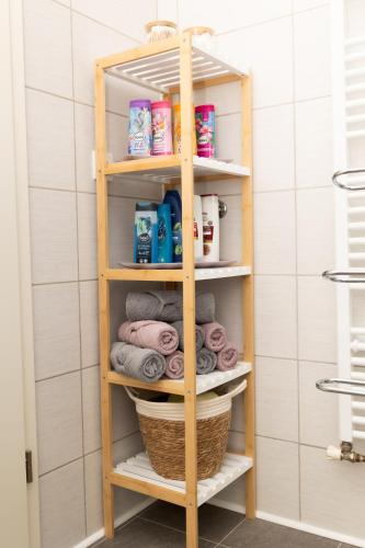 a wooden shelf in a bathroom with towels at Apartman Orhideja in Gospić