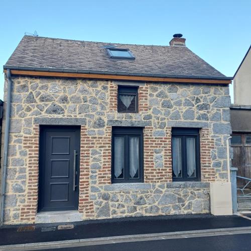 a stone house with two windows and a door at La petite Maison in Fromelennes