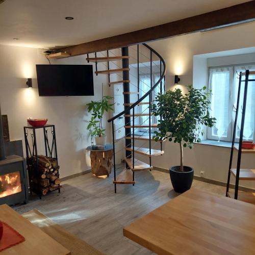 a living room with a spiral staircase and a fireplace at La petite Maison in Fromelennes