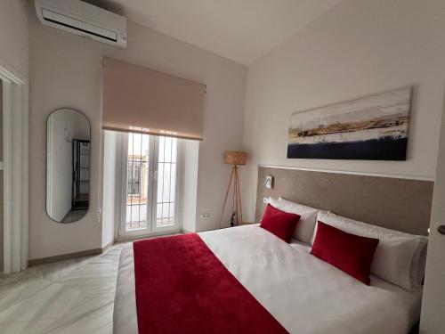 a bedroom with a large bed with red pillows at Iberflat San Gregorio in Seville