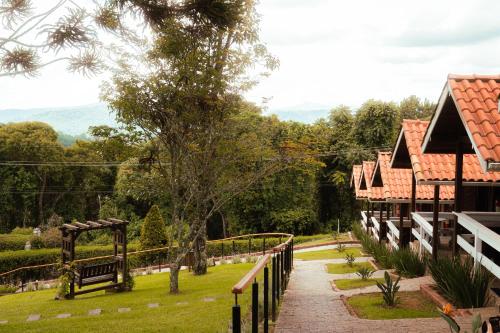 a walkway in a park next to a building at Pousada das Pedras in Monte Verde