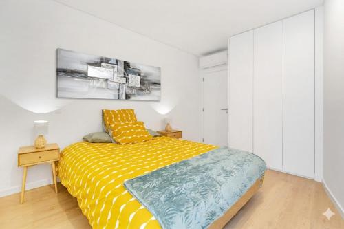 a bedroom with a yellow bed with a yellow and blue blanket at Leiria Boutique Apartment in Leiria