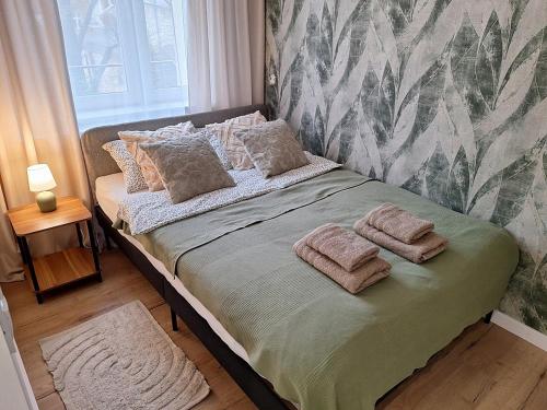 a bed with pillows on it in a bedroom at Apartament TARNÓW LWOWSKA CENTRUM in Tarnów