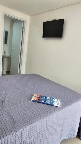 a bed with a purple comforter on top of it at Hotel In Box - Roseira in Roseira