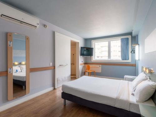 a bedroom with a large bed and a mirror at ibis budget RJ Praia de Botafogo in Rio de Janeiro