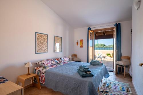 a bedroom with a bed and a door to a patio at Ri Ale Sa prassa Sardegna Ogliastra in Bari Sardo