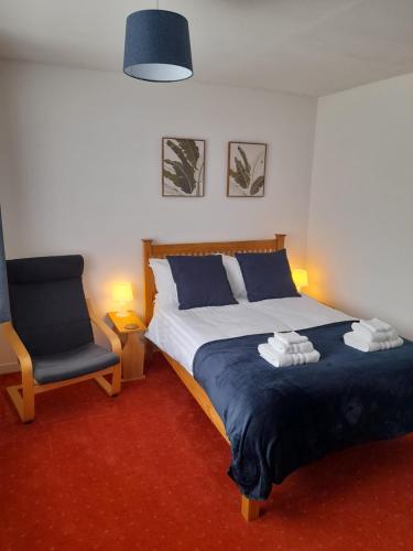 a bedroom with a bed and a blue chair at Greenview in Didcot