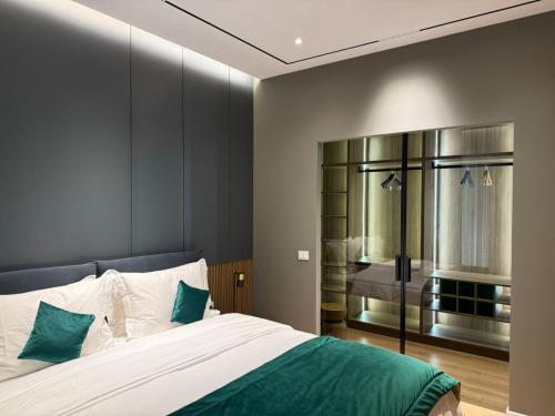 a bedroom with a large white bed with green pillows at Vila 76 Belvedere in Korçë