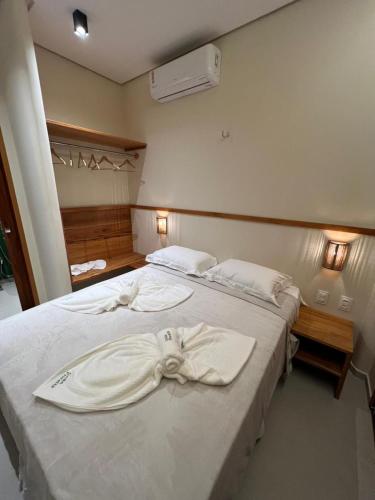 a bedroom with two beds with white sheets with a bow on them at Casa Floratta - Flecheiras in Flecheiras