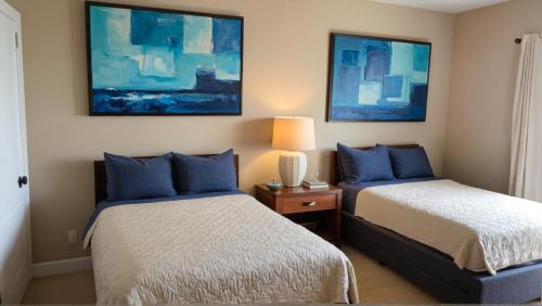 a bedroom with two beds and a lamp on a table at Stylish Residences Near Art Deco and LA Hotspots in Los Angeles