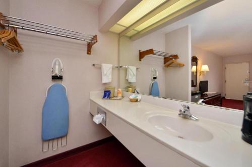 ein Badezimmer mit Waschbecken und großem Spiegel in der Unterkunft Nations Inn - West Jefferson in West Jefferson