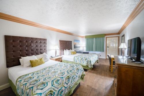 a hotel room with two beds and a flat screen tv at Accommodations By Willow Brook Lodge in Pigeon Forge