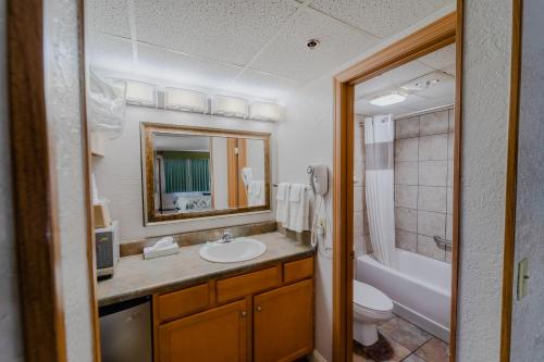 a bathroom with a sink and a toilet and a tub at Accommodations By Willow Brook Lodge in Pigeon Forge