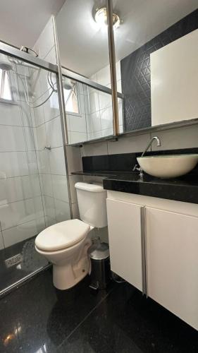 a bathroom with a white toilet and a sink at Apartamento completo no Planalto in Belo Horizonte