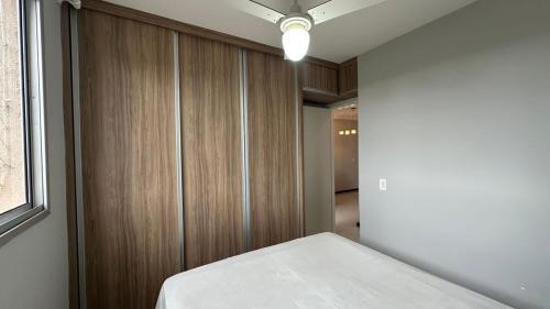 a bedroom with a bed and a wooden wall at Apartamento completo no Planalto in Belo Horizonte