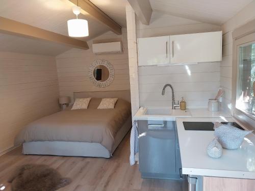 a small bedroom with a bed and a sink at Chalet cosy avec terrasse & hamac, calme, proche plage, parking, NC Properties in Grimaud