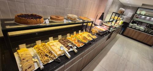a display case with many different types of cakes and pastries at Hotel Alvorada in Concordia