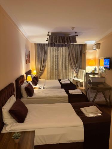 ein Hotelzimmer mit zwei Betten und einem Schreibtisch in der Unterkunft SRF Boutique Hotel in Eskisehir
