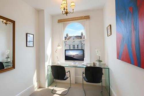 a home office with a desk and a window at Burlington Palace Eastbourne Seafront Villa with Garden. in Eastbourne