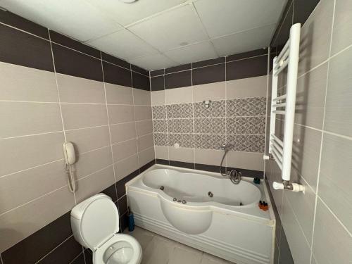 ein Badezimmer mit Badewanne und Toilette und ein Telefon in der Unterkunft SRF Boutique Hotel in Eskisehir