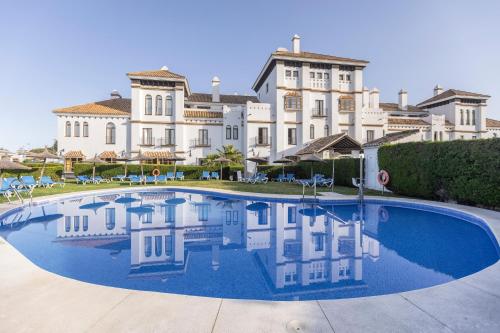 a large house with a large pool in front of it at BLUESEA El Cortijo in Matalascañas