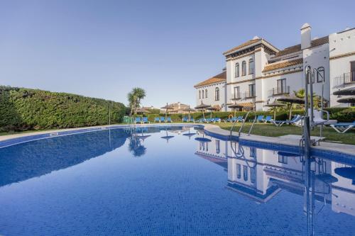 a large swimming pool in front of a building at BLUESEA El Cortijo in Matalascañas