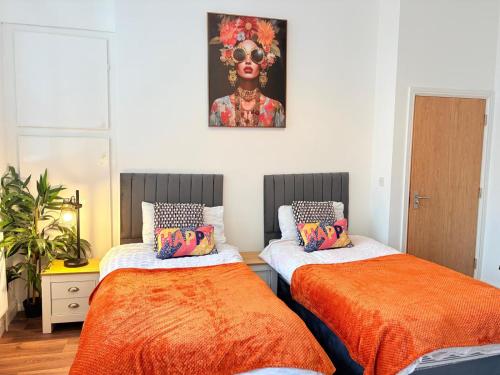 two beds in a room with a painting on the wall at Stylish Studio flat 5, ensuite, kitchenette, Wifi,Parking,Smart TV,Contractors,NHS,Families welcome in West Bromwich