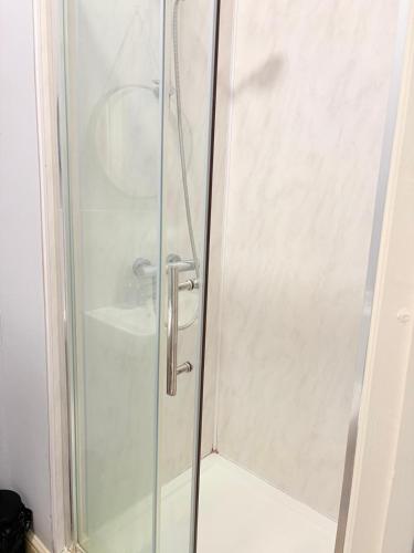 a shower with a glass door in a bathroom at Stylish Studio flat 5, ensuite, kitchenette, Wifi,Parking,Smart TV,Contractors,NHS,Families welcome in West Bromwich
