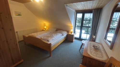 a bedroom with a bed in a room with windows at Upkammer im Park in Werdum