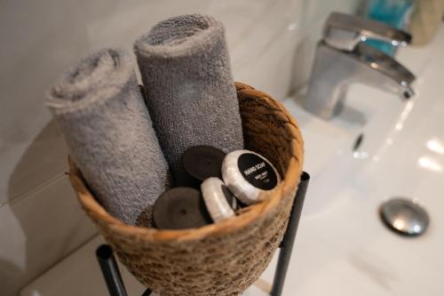 a basket of towels and other bathroom items on a sink at Maleme Maisonette in Maleme