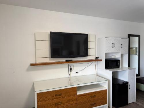 a living room with a tv on a wall at Siesta Inn Sarasota - Indian Beach in Sarasota