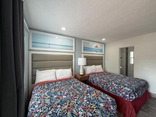 a hotel room with two beds and two windows at Siesta Inn Sarasota - Indian Beach in Sarasota