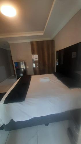 a bedroom with a large white bed in a room at National Lodge in Benoni