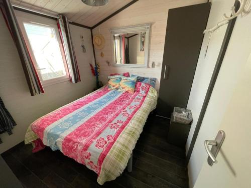 a small bedroom with a bed and a window at Chalet Chez Nous Castellane in Castellane