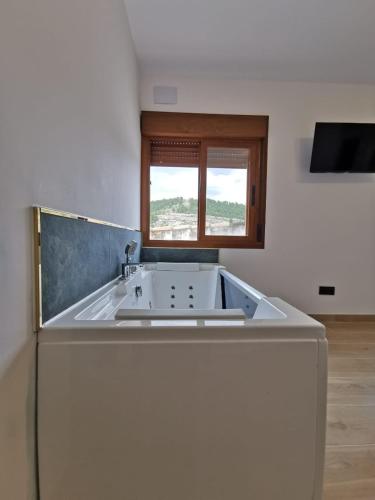 a white sink in a room with a window at Verde in Alcalá del Júcar