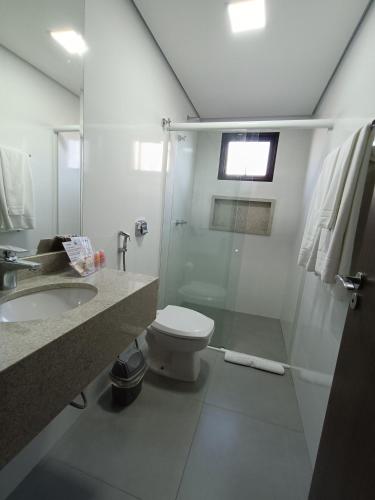 a bathroom with a shower and a toilet and a sink at Safa Hotel Foz in Foz do Iguaçu