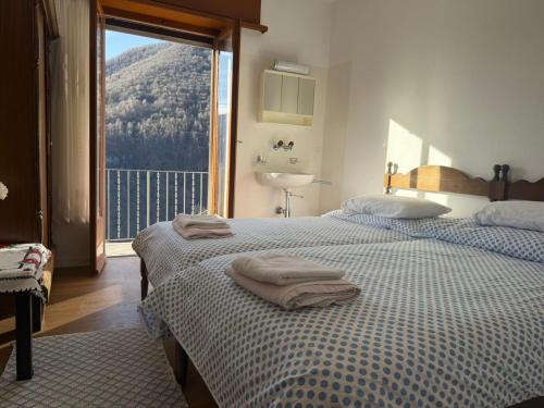 two beds in a room with a view of a mountain at La Pergola in Auressio