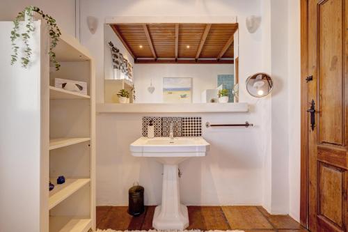 a bathroom with a white sink and shelves at Authentic apartment with pool and sea view in Estepona