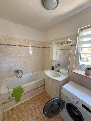a bathroom with a tub and a sink and a washing machine at Jarmila in Tachov