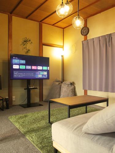 a living room with a large tv and a couch at Harbor Nook - Family Stay & Free 2 Car Parking in Takamatsu