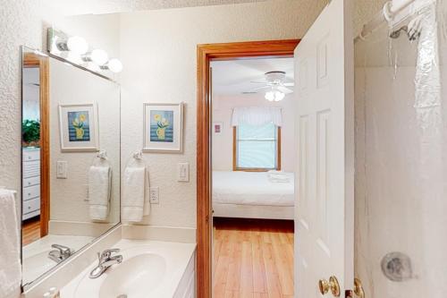 a bathroom with a tub and a sink and a bed at Dune Deck in Corolla