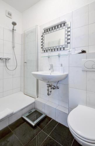 ein weißes Badezimmer mit Waschbecken und Toilette in der Unterkunft Hotel Landgasthof Simon in Waldrach