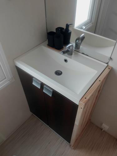 a bathroom vanity with a sink in a room at Le mobil home bleu ! Camping Naturiste in Montalivet-les-Bains