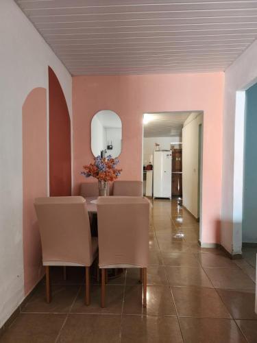 a dining room with pink walls and a table and chairs at Raízes do Sertão - Vale do Catimbau in Buíque