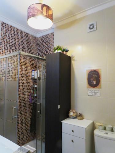 a bathroom with a shower and a toilet and a light at Al-Madan in Almada