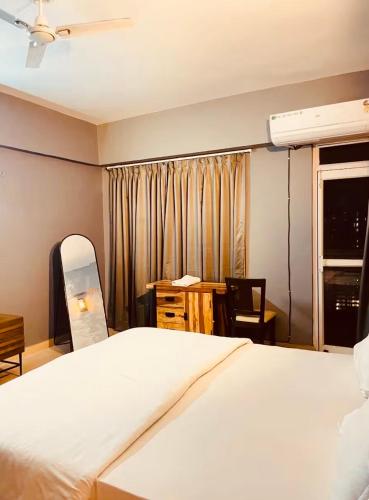 a bedroom with a bed and a desk and a window at Skyline Serenity by Vantage View in Nalmatha