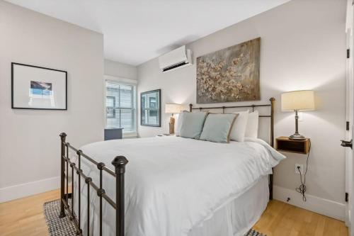 a bedroom with a large bed with white walls at The Heart of the West End #4 in Portland