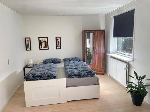 a bedroom with a bed with blue pillows on it at Room in Billund near Lego House & Legoland in Billund